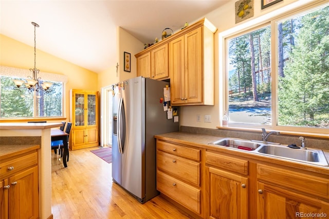 6752 S Columbine Rd, Evergreen, CO 80439 - kitchen featuring stainless steel refrigerator with ice dispenser, plenty of natural light, light wood-style flooring, a chandelier, and vaulted ceiling