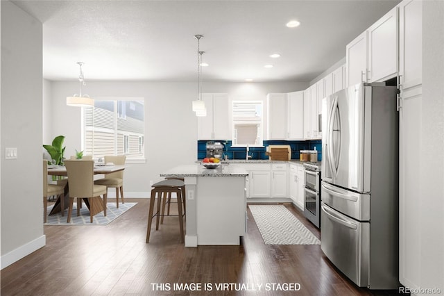 12714 E Dickenson Ave, Aurora, CO 80014 - kitchen with stainless steel appliances, a center island, a kitchen breakfast bar, healthy amount of natural light, and recessed lighting