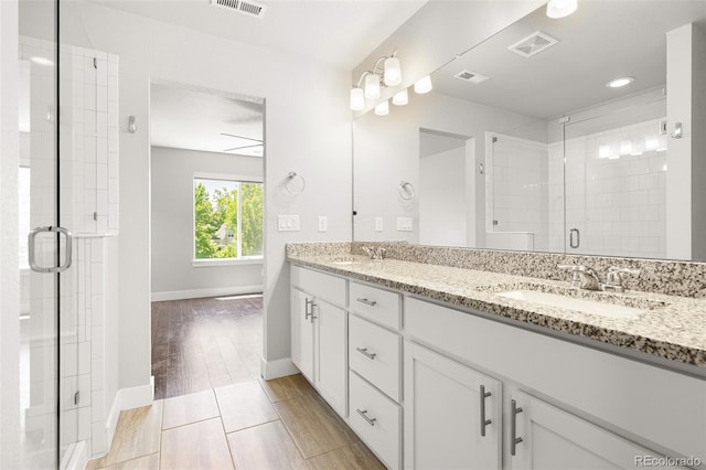 12714 E Dickenson Ave, Aurora, CO 80014 - full bath with double vanity, a stall shower, and wood finished floors