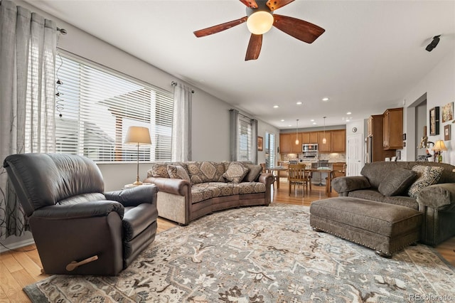 living area with recessed lighting, light wood-style flooring, and a ceiling fan