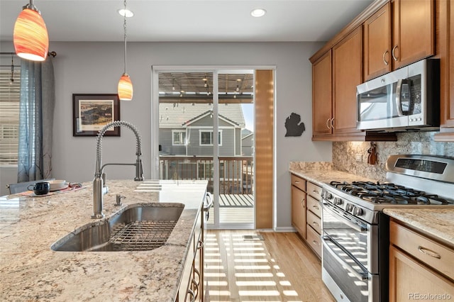 kitchen featuring tasteful backsplash, a sink, light wood-style floors, recessed lighting, and stainless steel appliances