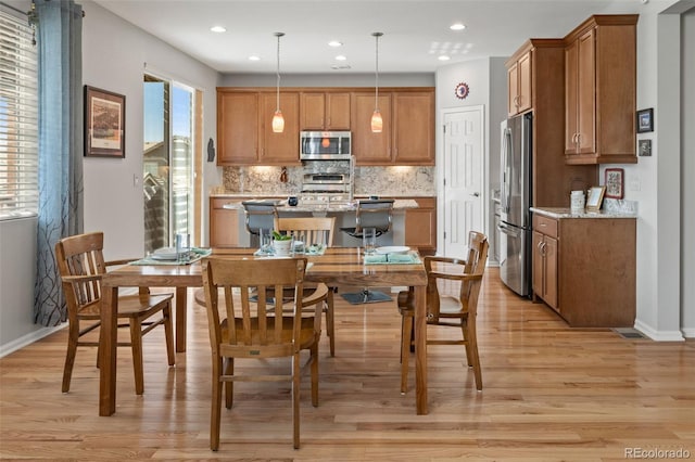 dining area with light wood finished floors, baseboards, and recessed lighting