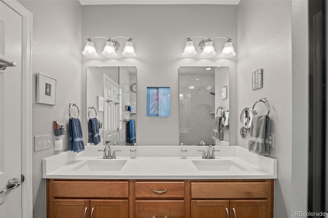 full bath with a sink, a tile shower, and double vanity