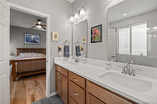 ensuite bathroom featuring a sink, a ceiling fan, connected bathroom, and double vanity