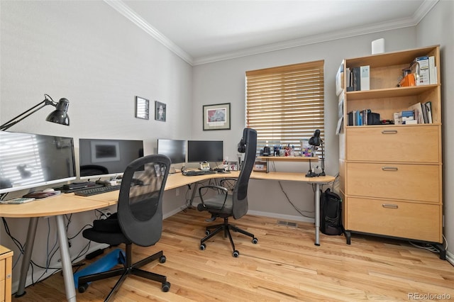 home office with crown molding, light wood-style flooring, and baseboards