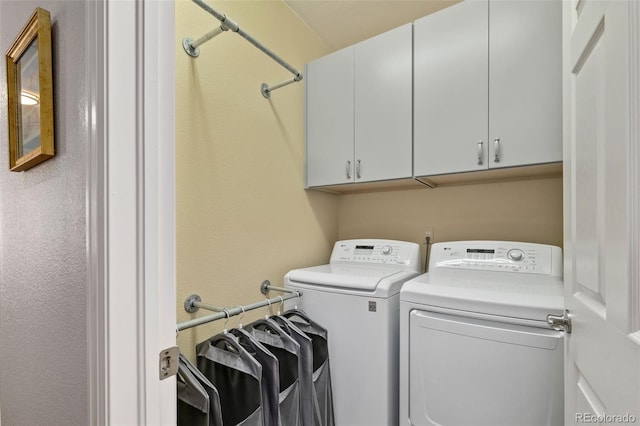 laundry room featuring washing machine and dryer and cabinet space