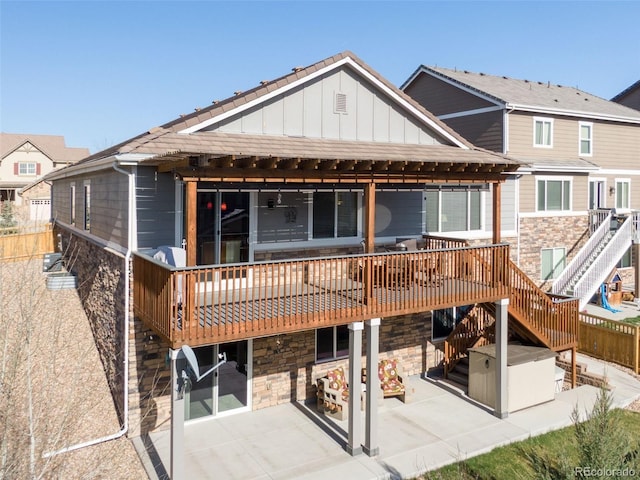 back of house featuring board and batten siding, a patio area, stone siding, and stairway