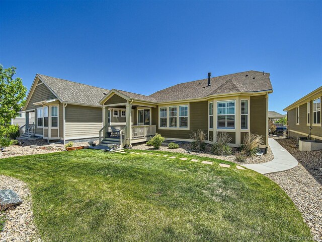 15347 Quince Cir, Thornton, CO 80602 - back of property with covered porch, a yard, and a shingled roof