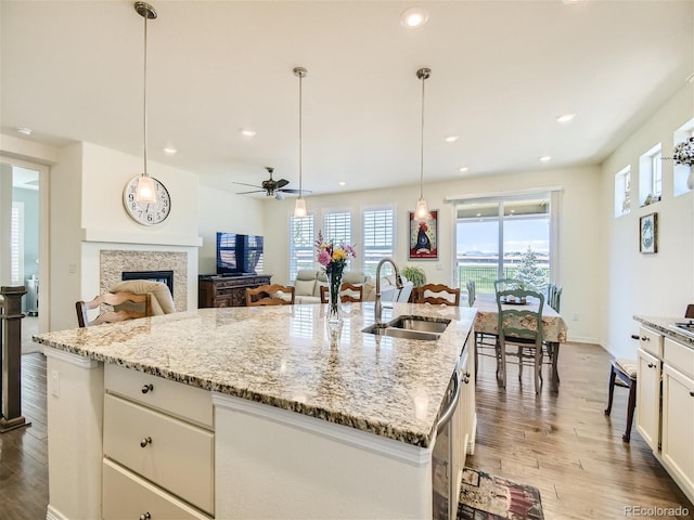 15347 Quince Cir, Thornton, CO 80602 - kitchen featuring a sink, a fireplace, wood finished floors, ceiling fan, and recessed lighting