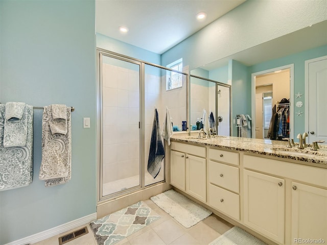 15347 Quince Cir, Thornton, CO 80602 - bathroom featuring a shower stall, double vanity, a spacious closet, tile patterned flooring, and recessed lighting