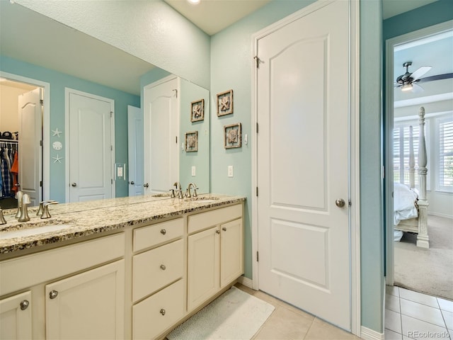 15347 Quince Cir, Thornton, CO 80602 - bathroom featuring tile patterned floors, ceiling fan, double vanity, connected bathroom, and baseboards