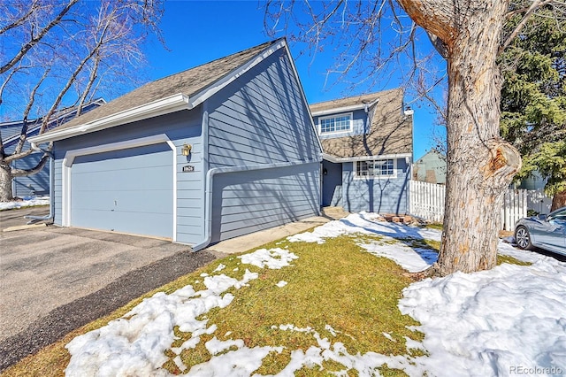 view of front of house with a garage and fence