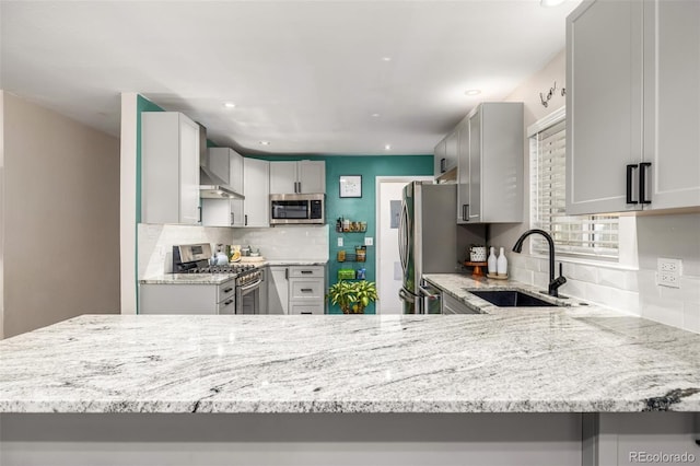 kitchen featuring sink, kitchen peninsula, gray cabinets, and stainless steel appliances