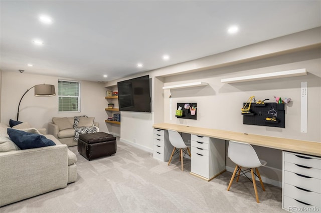 home office with light carpet and built in desk