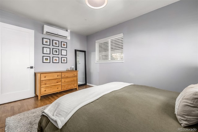 bedroom featuring an AC wall unit and dark hardwood / wood-style flooring