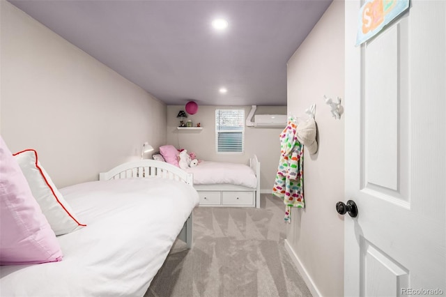 bedroom featuring a wall mounted AC and light carpet