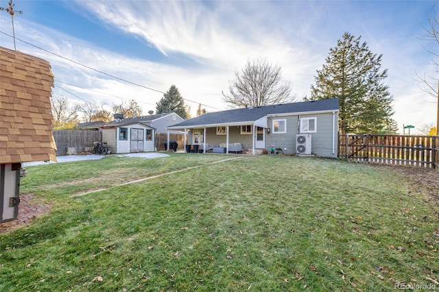 rear view of house featuring an outbuilding and a yard