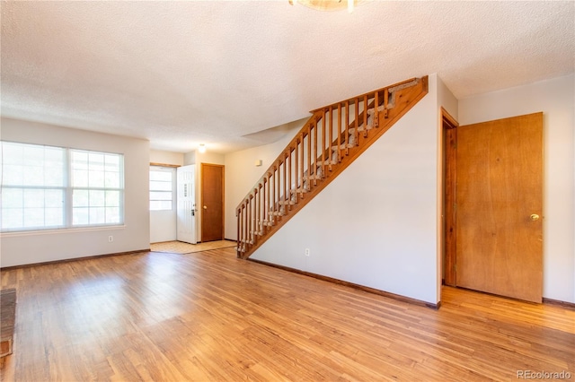 interior space with a textured ceiling and light hardwood / wood-style flooring