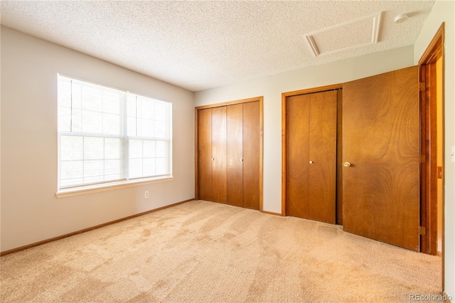 unfurnished bedroom with a textured ceiling and light colored carpet