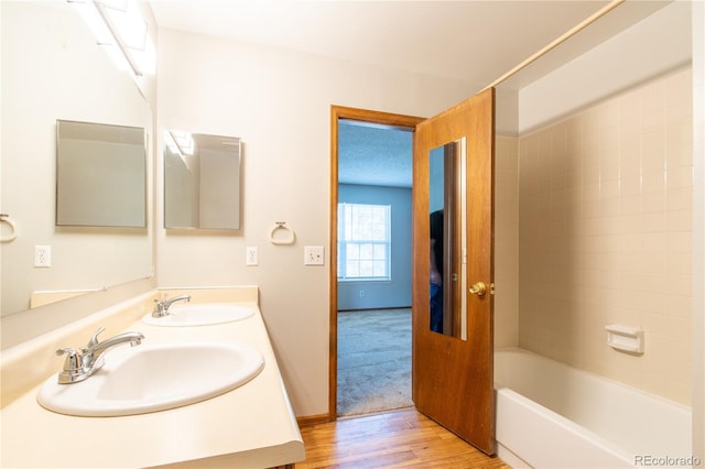 bathroom featuring vanity, wood-type flooring, and tiled shower / bath combo