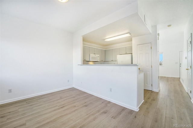 2644 Devonshire Ct, Denver, CO 80229 - kitchen with white appliances, light wood-style floors, light countertops, and a peninsula
