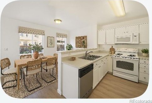 2644 Devonshire Ct, Denver, CO 80229 - kitchen featuring white appliances, light wood-style floors, white cabinetry, light countertops, and a peninsula