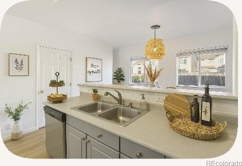 2644 Devonshire Ct, Denver, CO 80229 - kitchen featuring dishwasher, light wood finished floors, decorative light fixtures, light countertops, and arched walkways