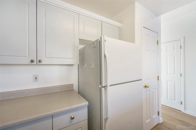 2644 Devonshire Ct, Denver, CO 80229 - kitchen with freestanding refrigerator, light countertops, light wood finished floors, and white cabinetry