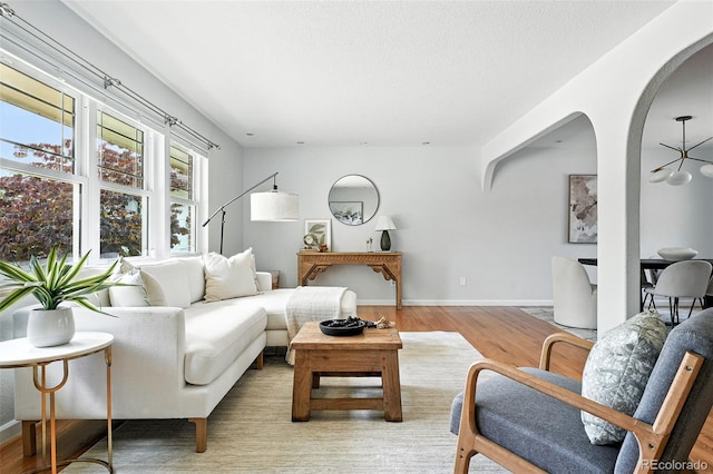 3608 S Newport Way, Denver, CO 80237 - living area with arched walkways, light wood-type flooring, and a textured ceiling