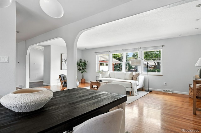 3608 S Newport Way, Denver, CO 80237 - dining space with arched walkways and light wood-style floors