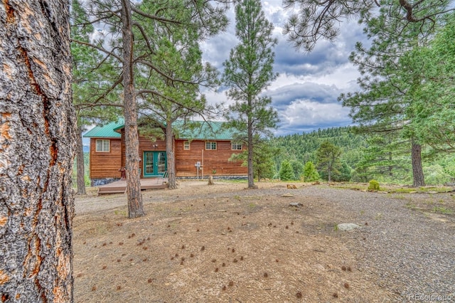 view of yard with a wooded view and a deck