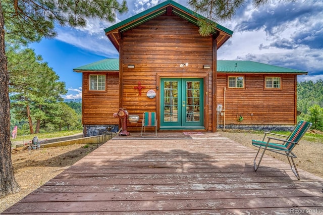 rear view of house featuring french doors, metal roof, and a deck