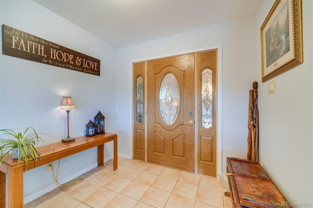 foyer entrance featuring light tile patterned floors and baseboards