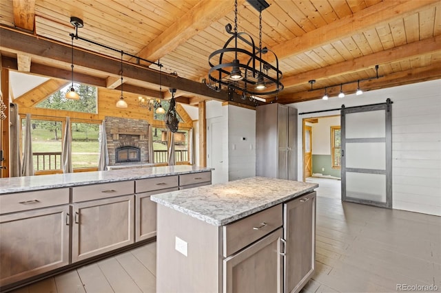 181 Sawmill Rd, Loveland, CO 80537 - kitchen with wooden walls, a barn door, a center island, wooden ceiling with exposed beams, and open floor plan