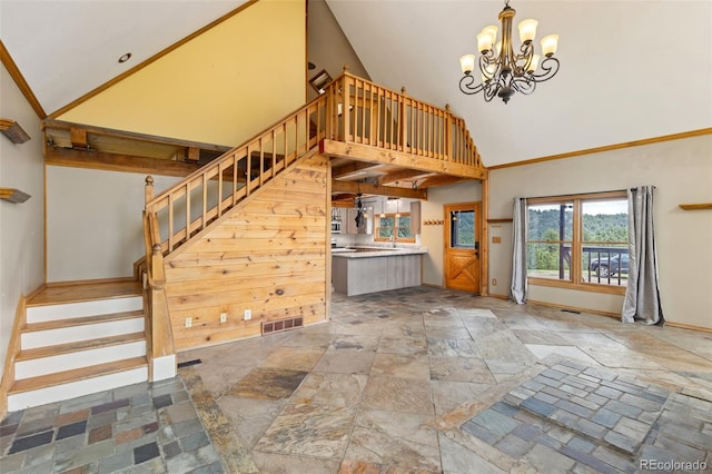 181 Sawmill Rd, Loveland, CO 80537 - staircase with high vaulted ceiling, stone tile floors, a chandelier, and baseboards