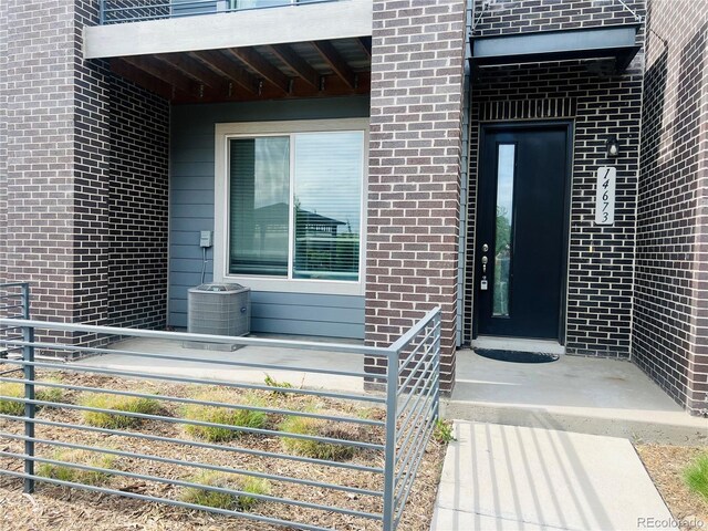 14673 E Belleview Dr, Aurora, CO 80015 - doorway to property with brick siding and cooling unit