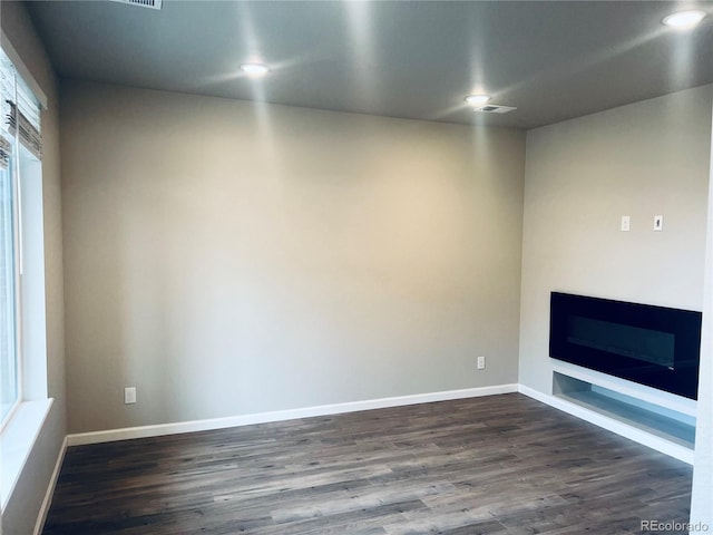 14673 E Belleview Dr, Aurora, CO 80015 - unfurnished living room featuring dark wood finished floors, a glass covered fireplace, baseboards, and recessed lighting