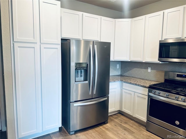 14673 E Belleview Dr, Aurora, CO 80015 - kitchen with stainless steel appliances, light stone countertops, white cabinetry, and light wood-style floors
