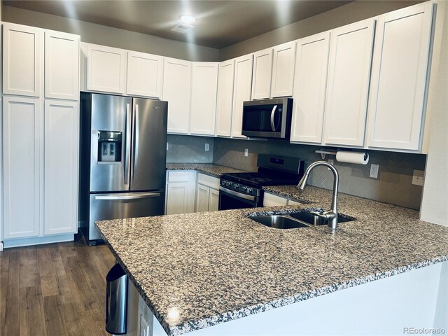 14673 E Belleview Dr, Aurora, CO 80015 - kitchen featuring appliances with stainless steel finishes, a sink, a peninsula, stone countertops, and white cabinetry