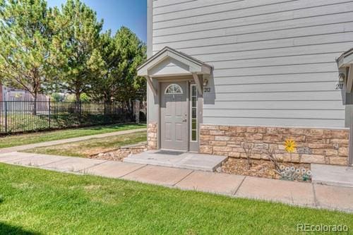 view of exterior entry featuring a lawn