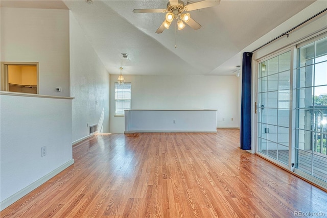 spare room featuring visible vents, vaulted ceiling, and light wood-style flooring