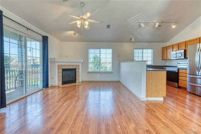 kitchen with vaulted ceiling, stainless steel appliances, light wood-style flooring, and visible vents