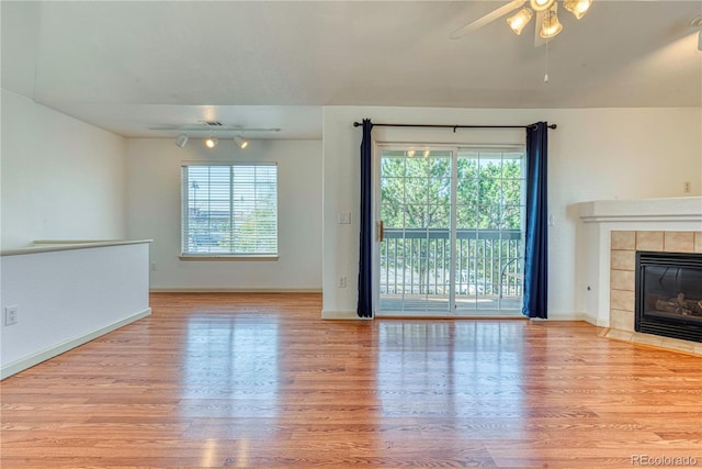 unfurnished living room with plenty of natural light, a fireplace, and wood finished floors