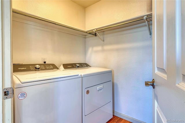 laundry room with washing machine and dryer, laundry area, and a textured wall