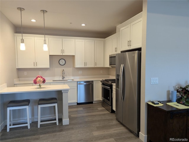 kitchen featuring a sink, stainless steel appliances, dark wood-style flooring, and white cabinetry