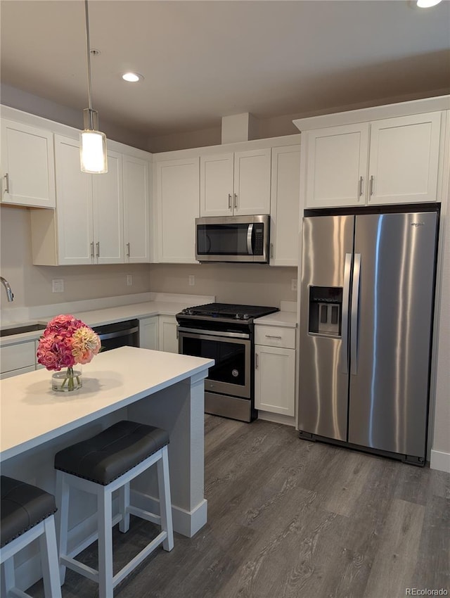 kitchen with appliances with stainless steel finishes, white cabinets, recessed lighting, and dark wood-style floors