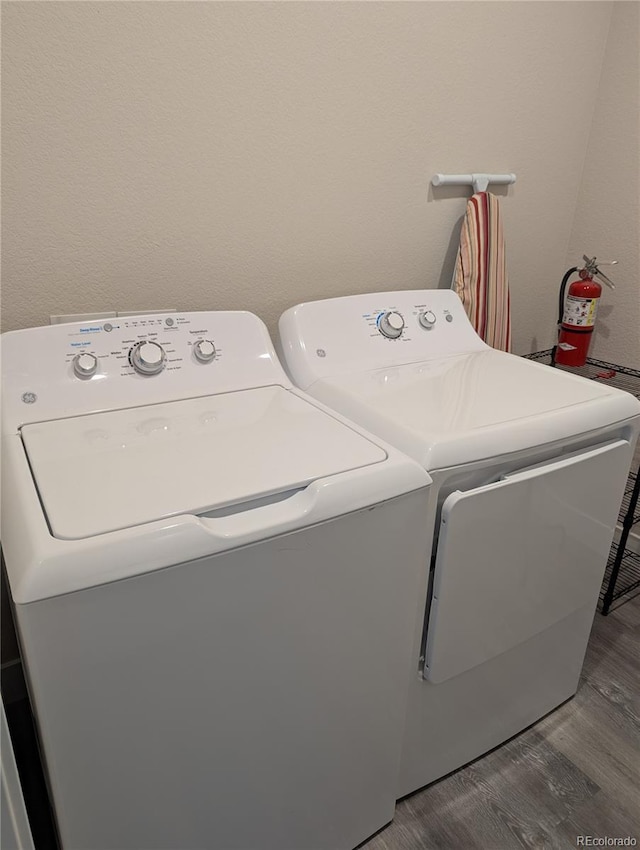laundry room featuring laundry area, washing machine and dryer, and wood finished floors