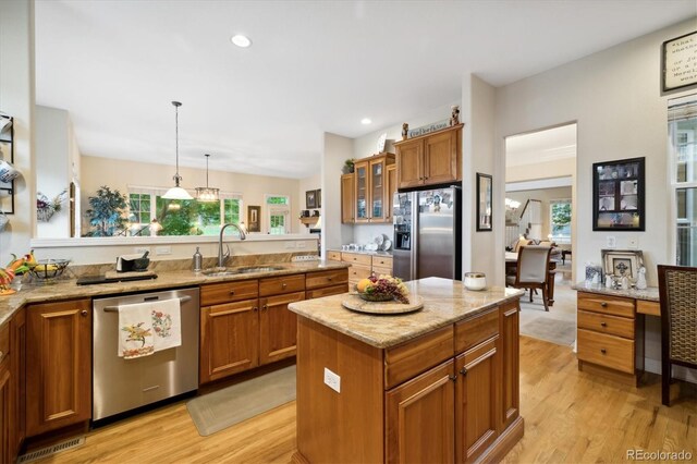 24422 E Frost Dr, Aurora, CO 80016 - kitchen featuring appliances with stainless steel finishes, brown cabinetry, light wood finished floors, glass insert cabinets, and recessed lighting