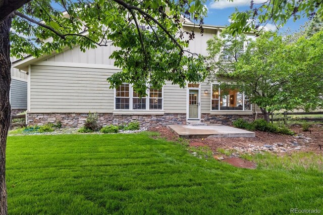 24422 E Frost Dr, Aurora, CO 80016 - back of property featuring stone siding and a lawn