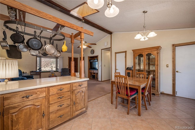 interior space with ceiling fan with notable chandelier, a textured ceiling, lofted ceiling with beams, and light tile floors